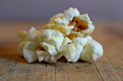 Crunchy White Popcorn Kernels on Rustic Wood for Movie Snacks image