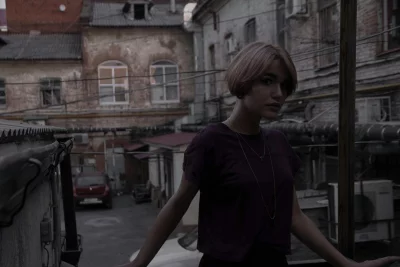 Young woman with short hair posing in urban alleyway