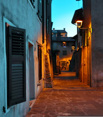 Atmospheric European Alleyway at Twilight with Warm Streetlight Glow image