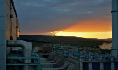 Industrial Power Plant and Green Mountains at Sunset image