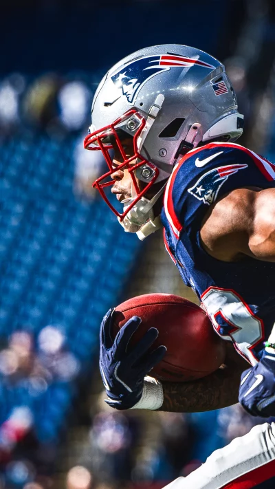 New England Patriots player carries the football during a game