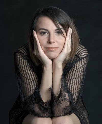 Pensive Woman in Elegant Black Lace Top with Hands Cupping Chin image