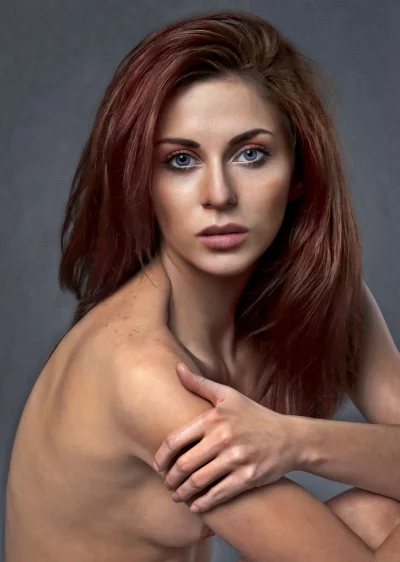 Captivating Young Redhead Woman with Intense Blue Eyes and Bare Shoulders image