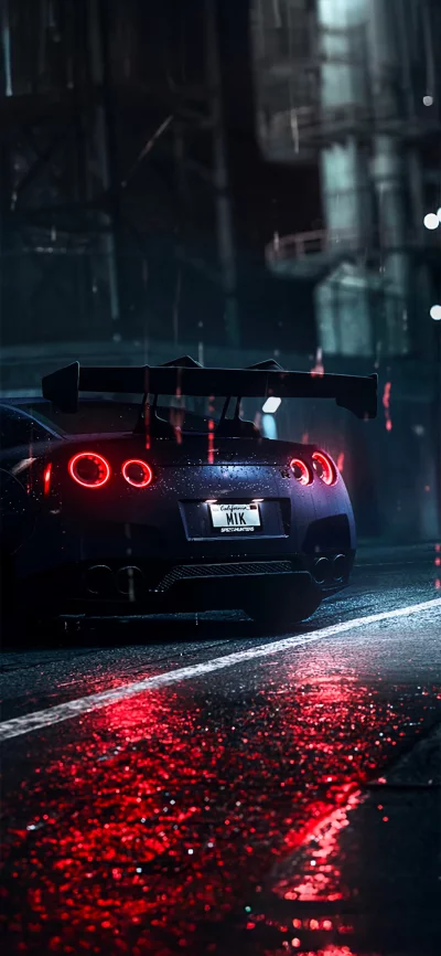 Powerful Sports Car Taillights Illuminating Wet City Street at Night image