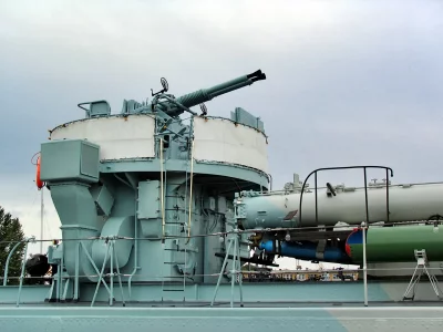 Naval Anti-Aircraft Gun and Torpedo Launcher on Warship Deck Under Grey Sky image
