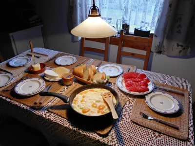 Delicious Homemade Breakfast Spread with Fresh Eggs, Artisan Bread, Assorted Cheeses and Sliced Tomatoes image