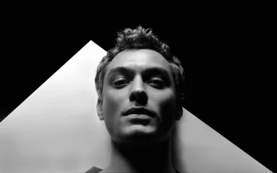 Intense Black and White Portrait of a Man with Dramatic Lighting and Geometric Background image