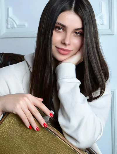 Beautiful Young Woman Leaning with Hand on Chin Looking at Camera in a Casual Pose image