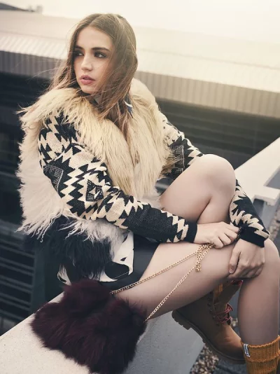 Stylish young woman in cozy fur trimmed outfit posing outdoors image