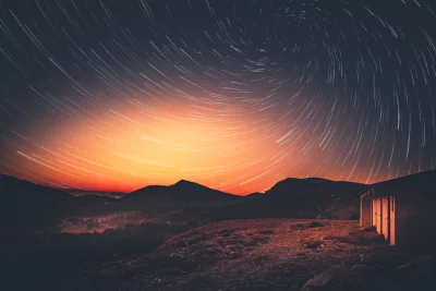 Long Exposure Star Trails Over Mountain Landscape with Horizon Glow image