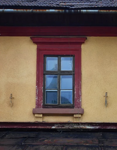 Weathered architectural facade of an old building with a rustic window and peeling paint image