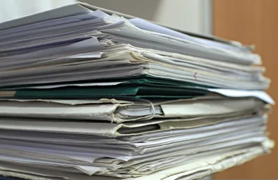 Untidy Stack of Aged Documents and Files with Green Folder image