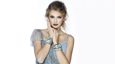 Elegant Blonde Woman in Embellished Blue Dress with Statement Bracelets on White image
