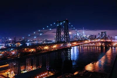 New York City Bridge at Night with Illuminated Skyline Reflections image