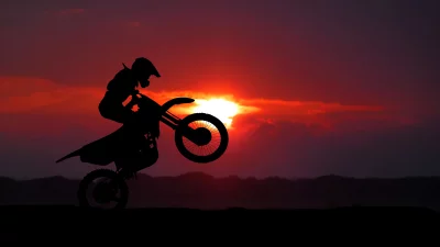 Motocross Rider Performing Wheelie at Sunset, Extreme Dirt Bike Silhouette image
