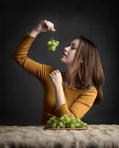 Young Woman Thoughtfully Holding Green Grapes, Healthy Eating Still Life image