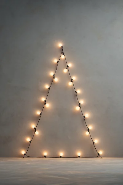 Minimalist Christmas Tree Shape Created with Glowing String Lights on Grey Wall