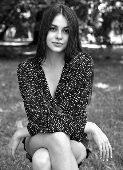Black and White Portrait of Young Woman in Polka Dot Blouse Outdoors image