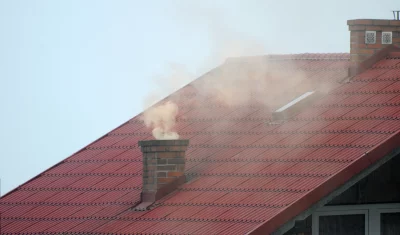 Red Tiled Roof with Smoking Brick Chimney and Skylight image