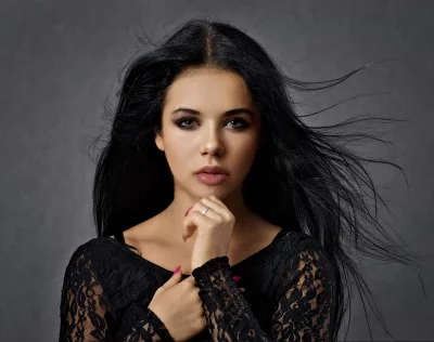 Captivating Woman with Flowing Dark Hair Posing in Black Lace Top image