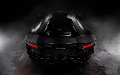 Sleek Black Lamborghini Aventador Rear View with Glowing Taillights on Dark Background image