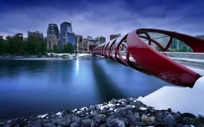 Calgary Peace Bridge and City Skyline at Dusk over Bow River in Winter image