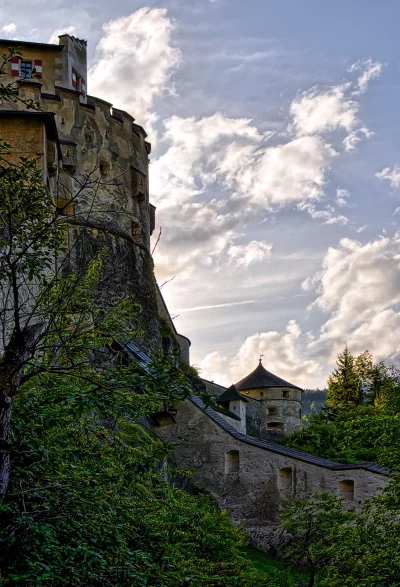 Historic Stone Castle Tower with Red Shutters and Dramatic Cloudy Sky image