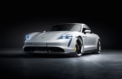 Silver Porsche Taycan Turbo S Electric Sports Car Parked on Dark Concrete Floor Studio Shot image