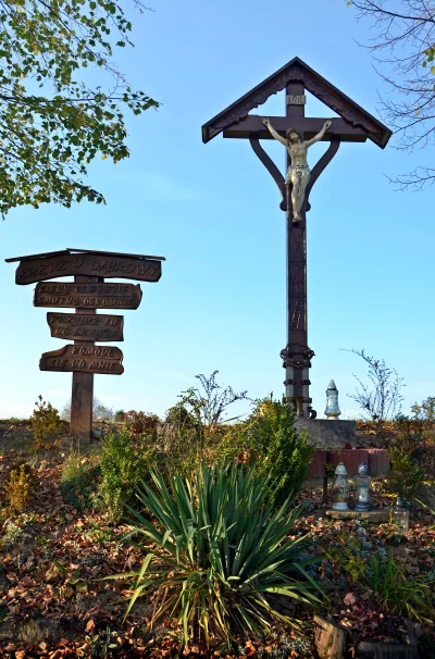 Rustic Wooden Crucifix with Jesus Figure, Polish Roadside Sign, Autumnal Rural Scene image