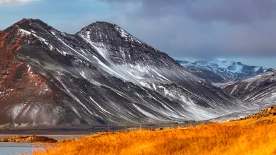 Ethereal Golden Light on Snow-Covered Mountains and Winter Grassland Scenic View image