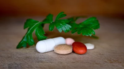 Assorted Pharmaceutical Pills and Natural Herb on Wooden Background image