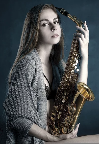 Elegant Female Artist with Golden Saxophone in Creative Studio Setting image