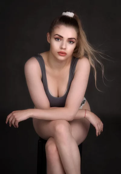 Pensive Blonde Woman Posing in Grey Top with High Ponytail image