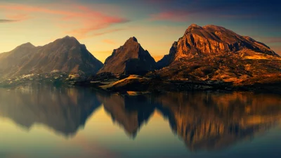 Majestic Mountain Peaks Reflected in Calm Lake Water at Golden Hour Sunset image