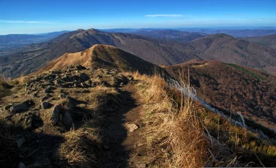 Vast Mountain Range with Hiking Path and Autumnal Forests Under Clear Blue Sky image