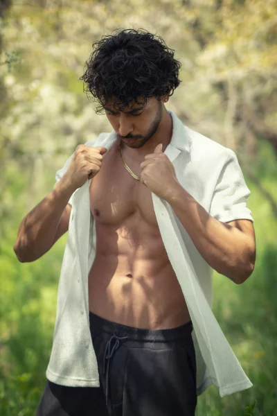 Toned Man in Open White Shirt Amidst Green Foliage