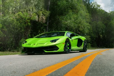 Stunning Green Lamborghini Aventador Performance Sports Car on Scenic Road Cinematic Wallpaper image