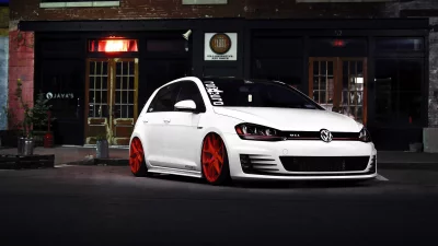 Sleek White Volkswagen Golf GTI with Vibrant Red Rims Parked at Night image