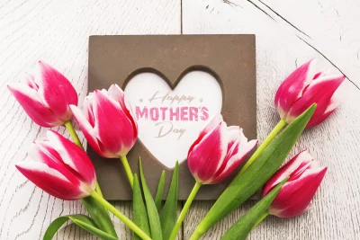Vibrant Pink Tulips and Heart Frame Celebrating Happy Mother's Day on Rustic White Wood image