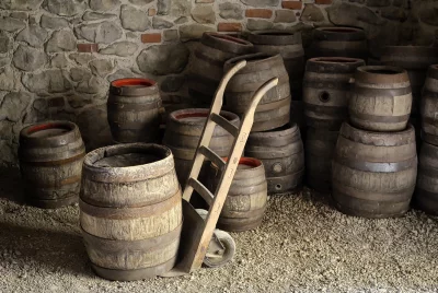 Rustic Wine Cellar with Old Wooden Barrels and Vintage Hand Truck image