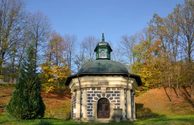 Historic Octagonal Chapel Amidst Autumn Trees Under Clear Blue Sky image