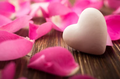 Romantic White Heart and Delicate Pink Rose Petals on Rustic Wood image