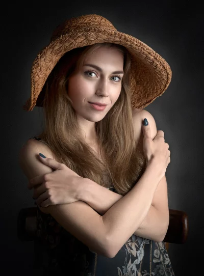 Smiling Young Woman in Straw Hat Posing with Crossed Arms for Portrait image