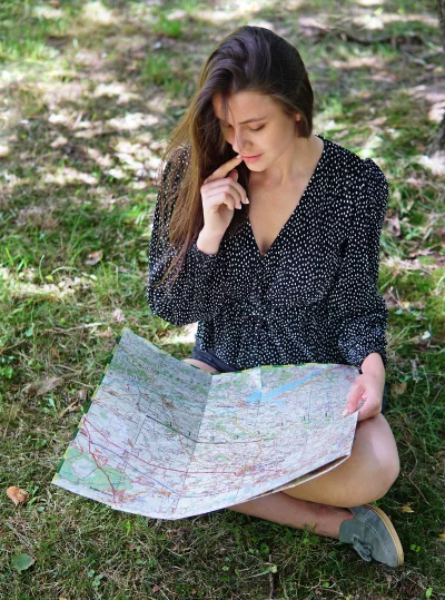 Thoughtful Young Woman Reading Paper Map, Planning Outdoor Adventure image