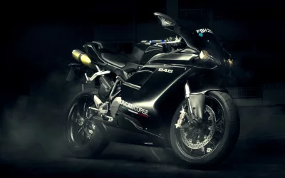 Sleek Black Ducati 848 Sportbike with Glowing Headlights in Smoky Dark Setting image