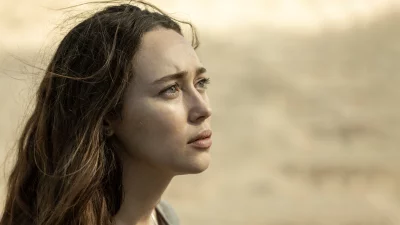 Pensive Woman with Windblown Hair and Green Eyes in Soft Light image