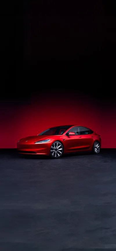 Sleek Red Tesla Sedan Showcased Against Dark Background