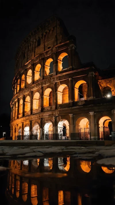 Colosseum at Night Illuminated by Warm Orange Light with Reflection
