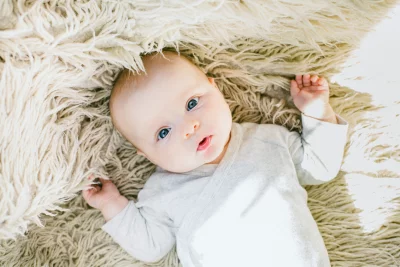 Sweet Infant with Captivating Blue Eyes on a Soft, Warm, Textured Rug image