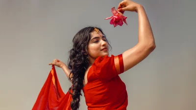 Graceful Indian Woman in Red Sari Holding Pink Lotus Flower for Cultural Beauty image